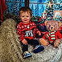toddler, child, smiling, sweater, mickey_mouse, teddy_bear, christmas, holiday, decorations, chair, fluffy, shoes, indoors, portrait, festive, winter, pine_trees, scarf, red, cozy
