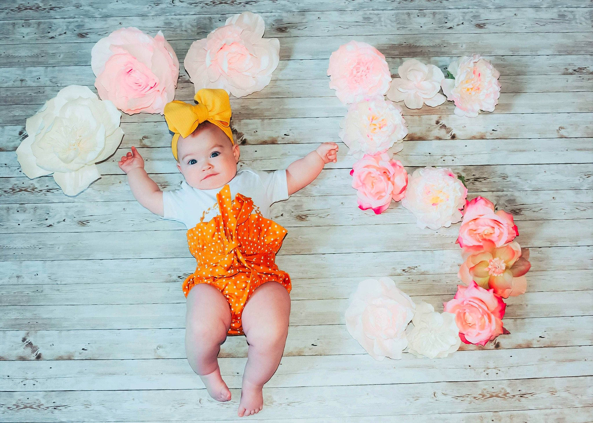 Emmie is registered to the contest to win money with this photo: baby_toddler_clothing, finger, flower, fun, gesture, hand, happy, headgear, orange, party_supply, peach, people_in_nature, person, petal, pink, plant, red, skin, smile, toddler