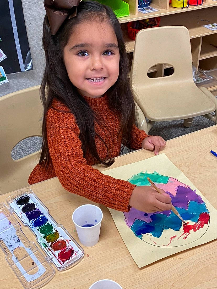 Gracie is registered to the contest to win money with this photo: art, beauty, chair, child, desk, electronic_device, finger, fun, gadget, happy, joy, learning, leisure, nail, office_supplies, paint, person, play, recreation, smile