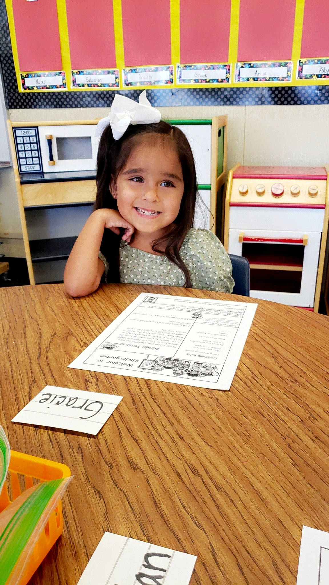 Gracie is registered to the contest to win money with this photo: chair, child, design, desk, flooring, font, happy, hardwood, joy, person, play, product, room, smile, snapshot, t_shirt, table, toddler, varnish, wood