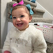 Samara joined the competition — help win amazing prizes! toddler, child, smiling, happy, hair_bows, white_sweater, pink_gloves, carpeted_stairs, basket, indoor, cute, person, portrait, young_child, playful, fashion, home, cozy, clothing, accessories