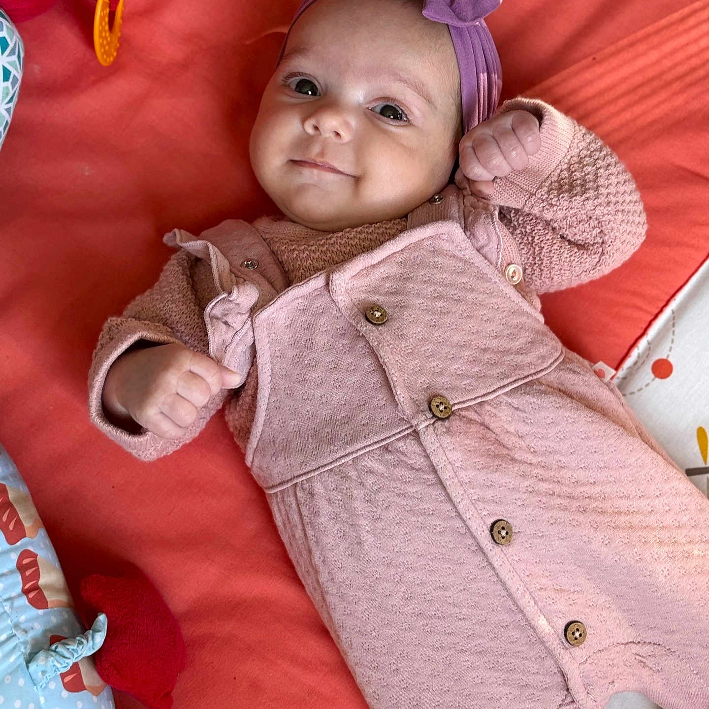 Zoélhya participe au concours pour gagner de l'argent avec cette photo : baby, blanket, buttoned_overall, child, colorful, cozy, cute, face, happy, headband, indoor, infant, lying_down, pink_clothing, portrait, purple_bow, small_hands, smiling, soft_toys, toy