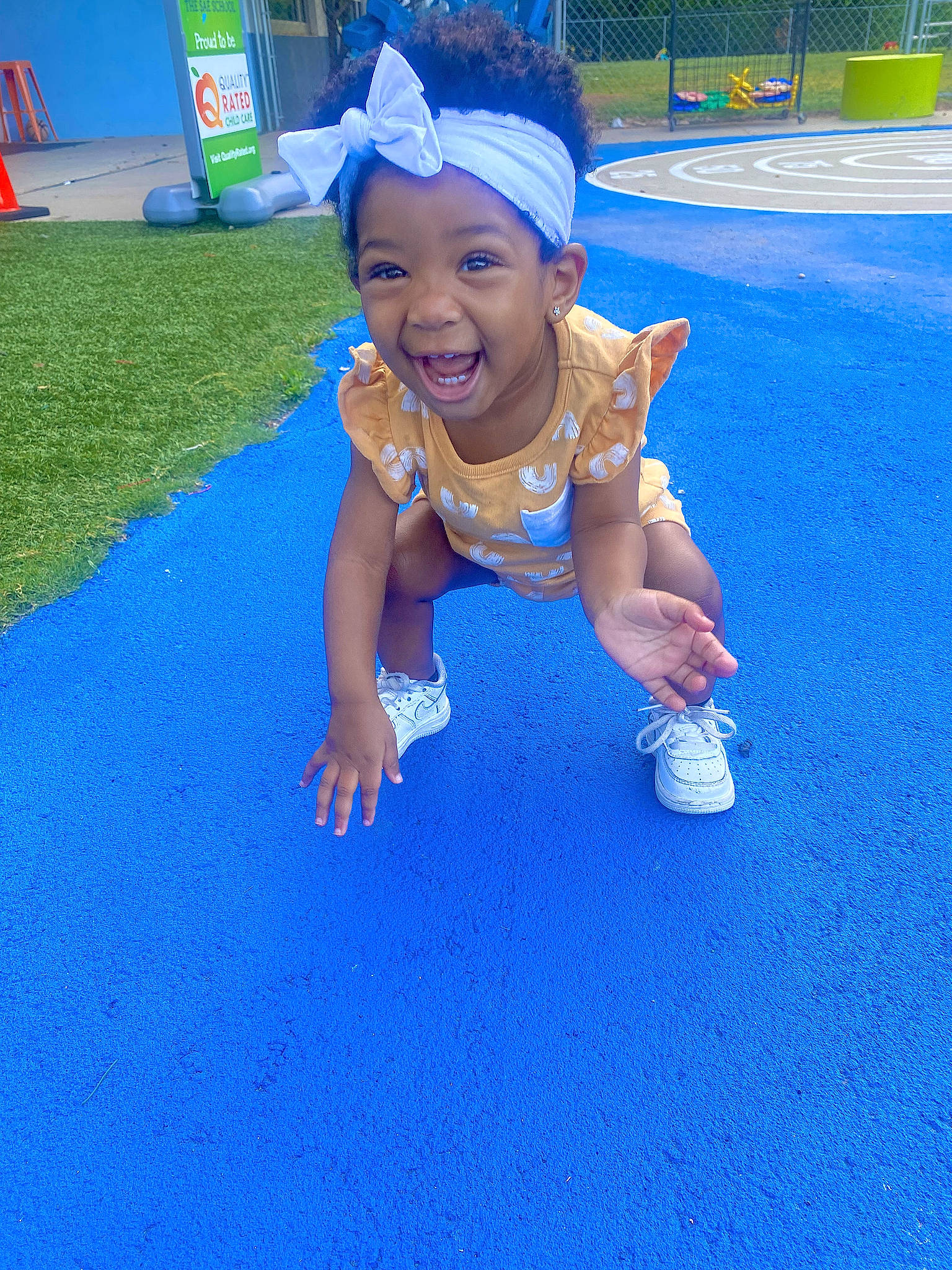 Khalani joined the competition — help win amazing prizes! asphalt, baseball_cap, blue, cap, child, city, electric_blue, flooring, fun, grass, happy, hat, headwear, leisure, outdoor_play_equipment, person, playground, recreation, sky, smile