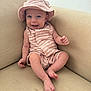 Blake is registered to the contest to win money with this photo: baby, beige, child, comfortable, couch, cute, expression, face, feet, hand, happy, hat, indoors, infant, portrait, relaxed, sitting, skin, smiling, striped_clothing