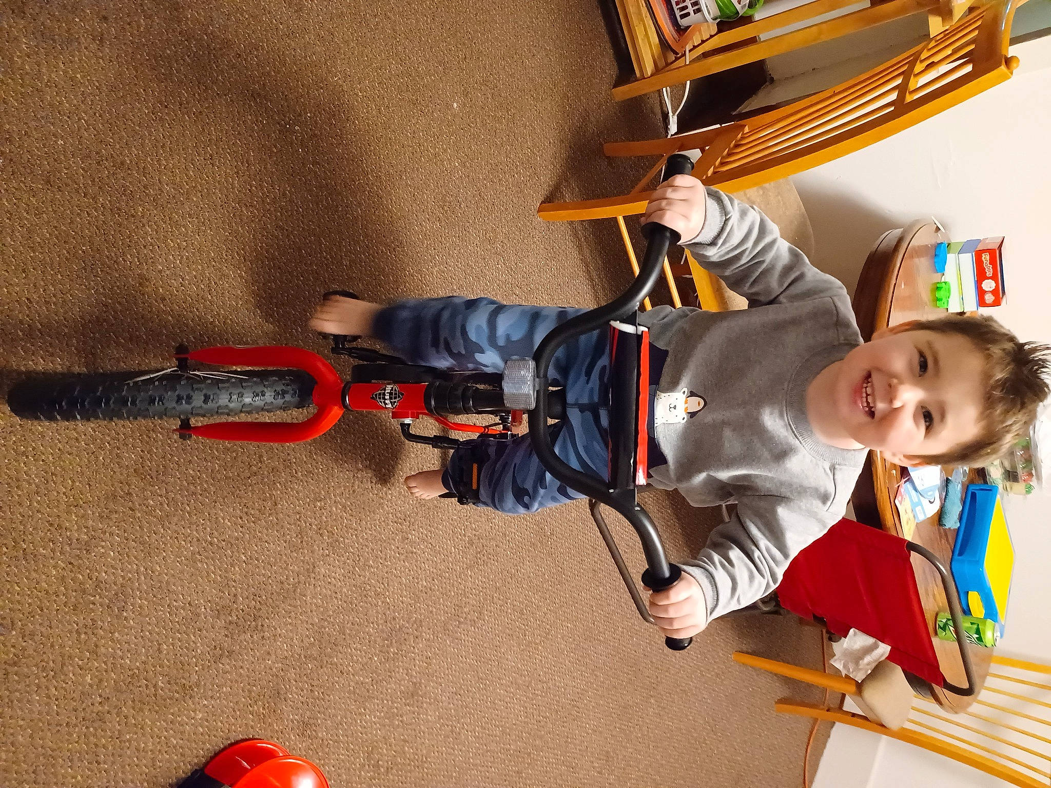 Bryce is registered to the contest to win money with this photo: baby_toddler_clothing, bookcase, carmine, child, flooring, fun, happy, hat, joy, person, personal_protective_equipment, play, recreation, shelf, sitting, smile, toddler, wood