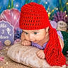 baby, child, red_hat, mermaid_costume, green_eyes, pillow, underwater_theme, decorations, purple_corals, starfish, seashells, pearls, lights, knitwear, cute, portrait, infant, costume, smiling, playful