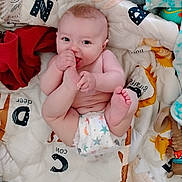 Cyrus is registered to the contest to win money with this photo: baby, infant, diaper, blanket, quilt, foot, hand, playful, smiling, cute, child, indoor, soft_toys, animal_print, colorful, happy, lying_down, cozy, skin, barefoot