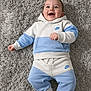 baby, barefoot, blue_clothing, casual_wear, child, cute, fashion, fluffy, happy, hoodie, indoor, infant, lying_down, nike, pants, playful, portrait, rug, smiling, white_clothing