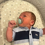 Marsh joined the competition — help win amazing prizes! baby, infant, pacifier, clothing, shirt, lying_down, blanket, stars, face, hand, newborn, cute, child, portrait, indoor, soft_focus, young, person, sleeping_area, nursery