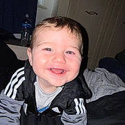 Marsh is registered to the contest to win money with this photo: baby, smiling, child, indoor, jacket, clothing, face, happy, person, bed, blanket, crawling, hoodie, adidas, young_child, cute, portrait, infant, cozy, soft_lighting