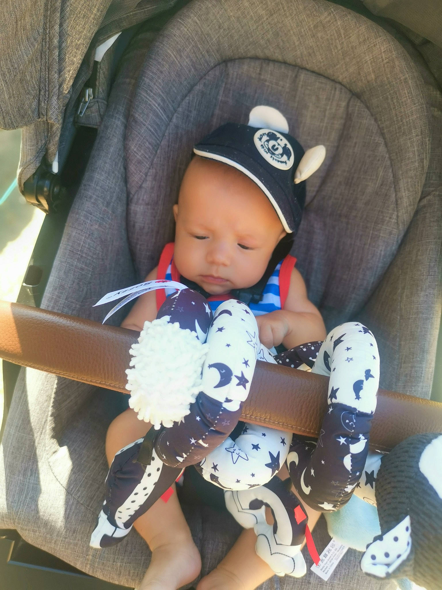 Liam a rejoint le concours — aidez-le/la à gagner de superbes lots ! baby, baby_carriage, baby_products, baby_safety, baby_sleeping, baby_toddler_clothing, cap, car_seat, child, comfort, electric_blue, fashion_accessory, headgear, human_leg, person, product, sitting, sock, sun_hat, thigh