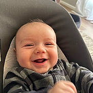 Finn joined the competition — help win amazing prizes! baby, smiling, infant, child, face, happy, striped_clothing, seat, cushion, indoor, living_room, portrait, person, young_child, head, comfort, cozy, expression, closeup, cheerful