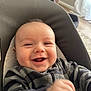 baby, smiling, infant, child, face, happy, striped_clothing, seat, cushion, indoor, living_room, portrait, person, young_child, head, comfort, cozy, expression, closeup, cheerful