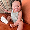 Clementine joined the competition — help win amazing prizes! baby, checkered, child, clothing, couch, cute, face, green, happy, indoors, infant, orange, person, pillow, purple, relaxing, shoes, sitting, smiling, striped