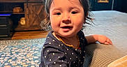 Clementine is registered to the contest to win money with this photo: child, clothing, couch, cozy, curtains, decor, face, hair, hand, indoor, living_room, person, polka_dot, portrait, rug, smiling, television, toddler, window, wooden_furniture