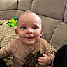 Tommy joined the competition — help win amazing prizes! baby, infant, child, smiling, face, eyes, toy, couch, furniture, blanket, indoor, clothing, person, happy, cute, homedecor, sitting, play, young, portrait