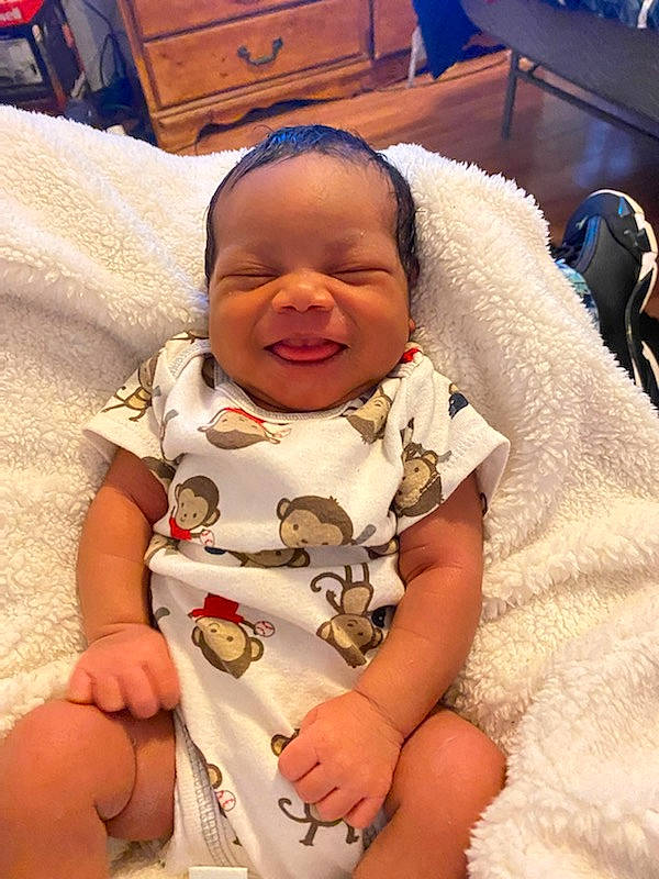 Gabrielle joined the competition — help win amazing prizes! baby, baby_products, baby_toddler_clothing, blue, cheek, child, comfort, dress, event, facial_expression, finger, fun, happy, linens, person, sitting, skin, smile, thumb, toddler