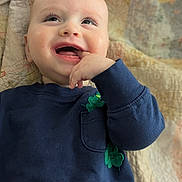 Jd joined the competition — help win amazing prizes! baby, child, smiling, hand, clothing, sweater, blue, green, clover, quilt, pattern, face, happy, lying_down, infant, cute, portrait, skin, young, playful