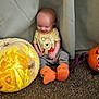 Owen joined the competition — help win amazing prizes! baby, child, pumpkin, carved_pumpkin, glowing, bat_pumpkin, orange_booties, winnie_the_pooh, smiling, happy, indoor, carpet, curtains, decor, halloween, fun, cute, sitting, face, person