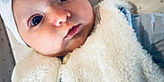 Lyna a rejoint le concours — aidez-le/la à gagner de superbes lots ! baby, infant, headband, bow, fluffy_vest, blanket, star_pattern, blue_clothing, face, wide_eyes, cute, portrait, child, soft_texture, closeup, lying_down, expression, person, indoors, warm_clothing