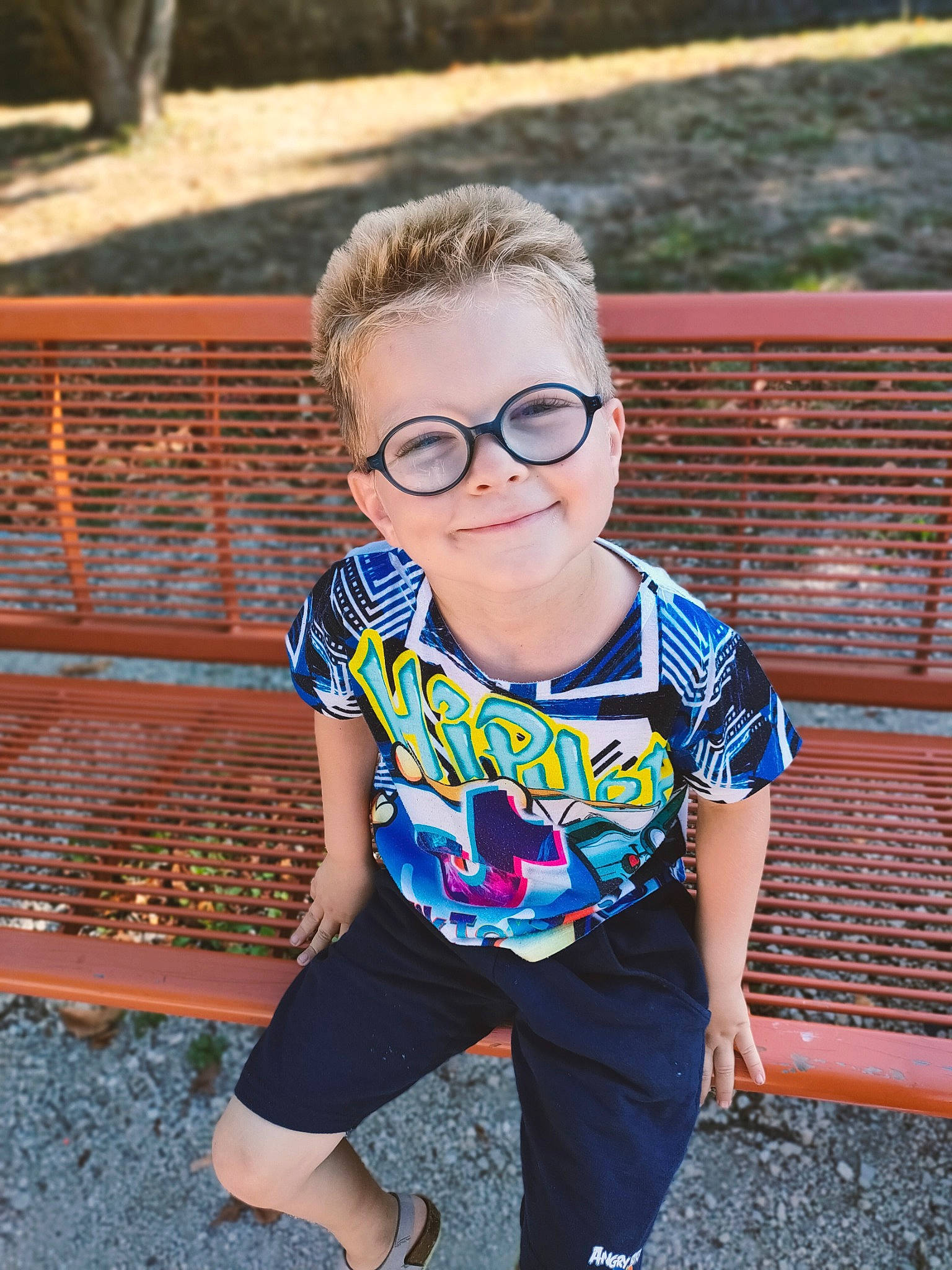 Nathan a rejoint le concours — aidez-le/la à gagner de superbes lots ! baby_toddler_clothing, blond, child, denim, electric_blue, eyewear, glasses, grass, hairstyle, happy, joy, leisure, person, sleeve, smile, sunglasses, t_shirt, toddler, vision_care, waist