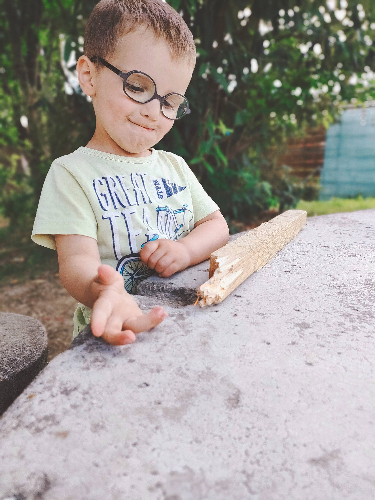 Leo participe au concours pour gagner de l'argent avec cette photo : child, eyewear, facial_expression, flash_photography, flooring, fun, glasses, grass, hand, happy, joy, leisure, people_in_nature, person, play, sitting, sleeve, smile, soil, t_shirt