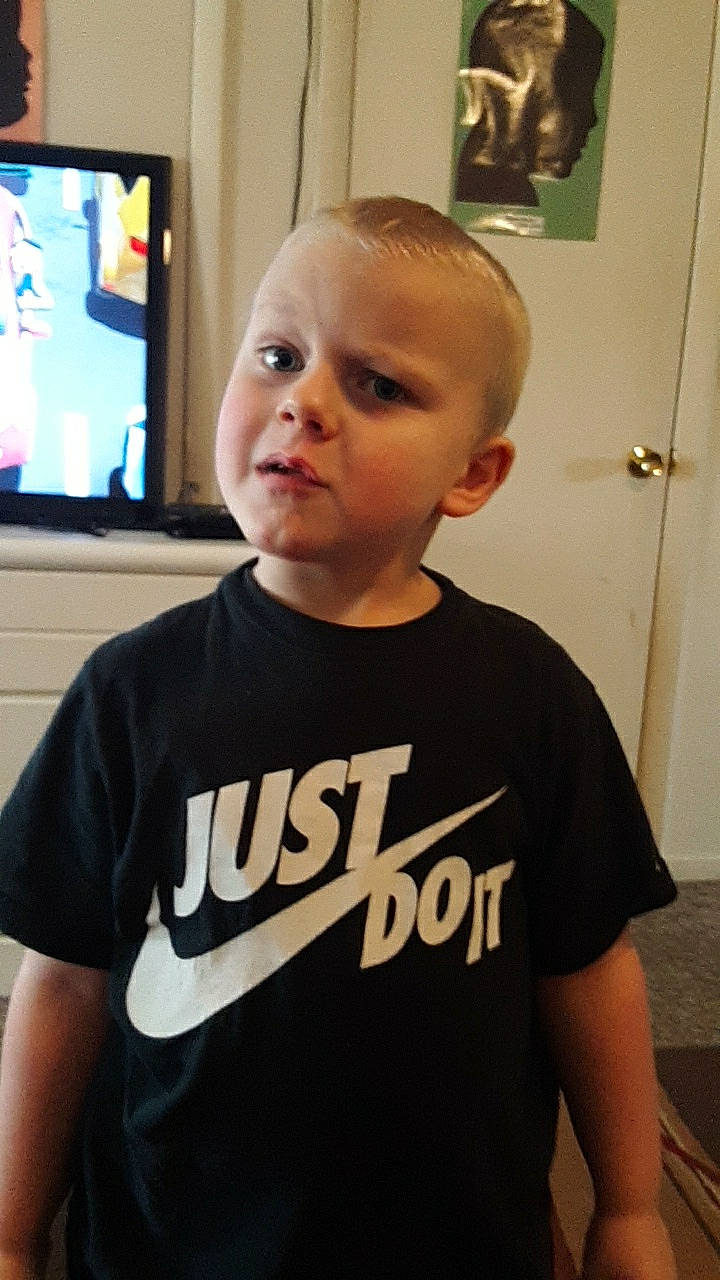 Owen is registered to the contest to win money with this photo: cheek, child, chin, cool, face, forehead, hair, hairstyle, head, neck, person, shirt, shoulder, sleeve, smile, t_shirt, toddler, top