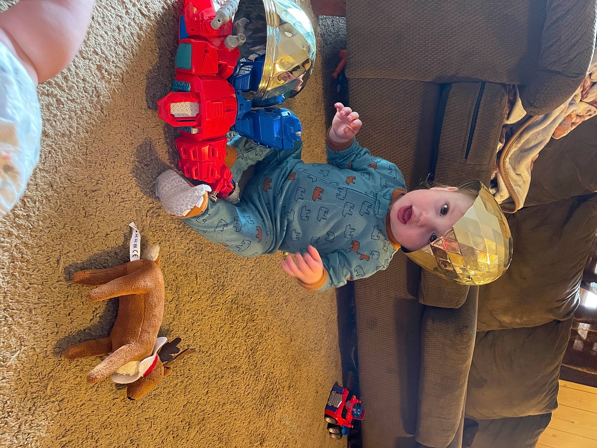 Lincoln is registered to the contest to win money with this photo: baby, baby_products, baby_toys, child, costume, fictional_character, flooring, fun, headwear, leisure, person, plastic, play, room, sitting, stuffed_toy, textile, toddler, toy, tree