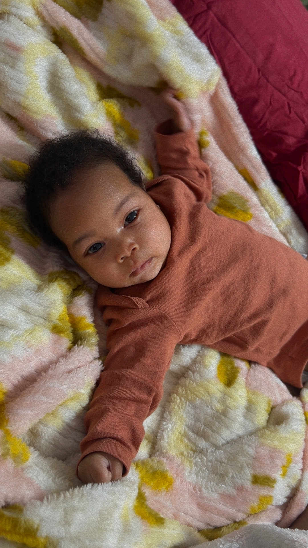 Xailia is registered to the contest to win money with this photo: baby, infant, child, blanket, soft, cozy, onesie, lying_down, arm, hand, face, curly_hair, indoor, cute, toddler, resting, fabric, texture, warm, pastel_colors