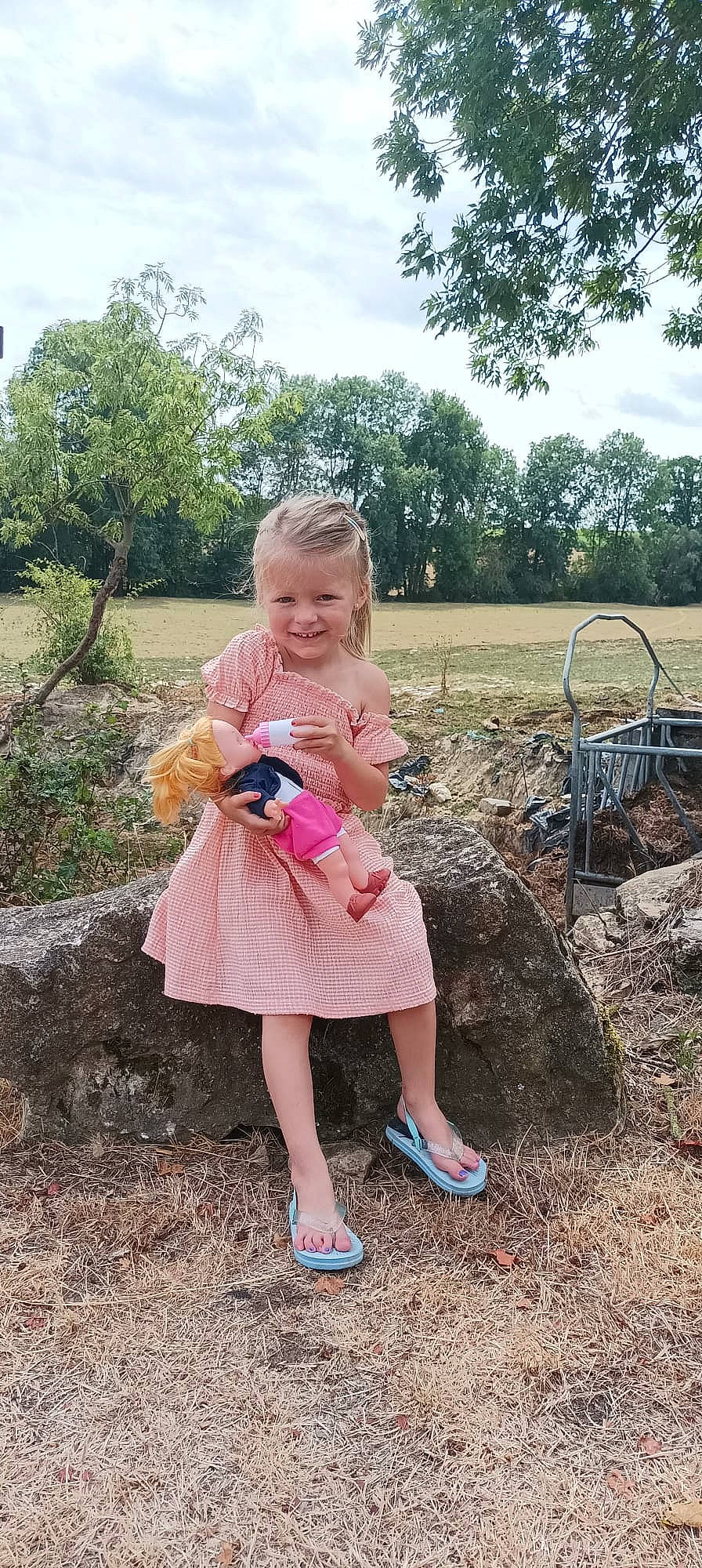 Jeanne a rejoint le concours — aidez-le/la à gagner de superbes lots ! automotive_tire, baby, baby_toddler_clothing, dress, event, fun, grass, grass_family, happy, joy, leisure, people, people_in_nature, person, plant, sandal, shoe, sitting, sky, smile