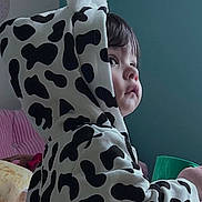 Quinn joined the competition — help win amazing prizes! books, child, clothing, cow_pattern, cozy, cute, ears, face, furniture, hoodie, indoor, person, pink_couch, portrait, shelf, side_view, soft_lighting, teal_wall, toddler, young_child