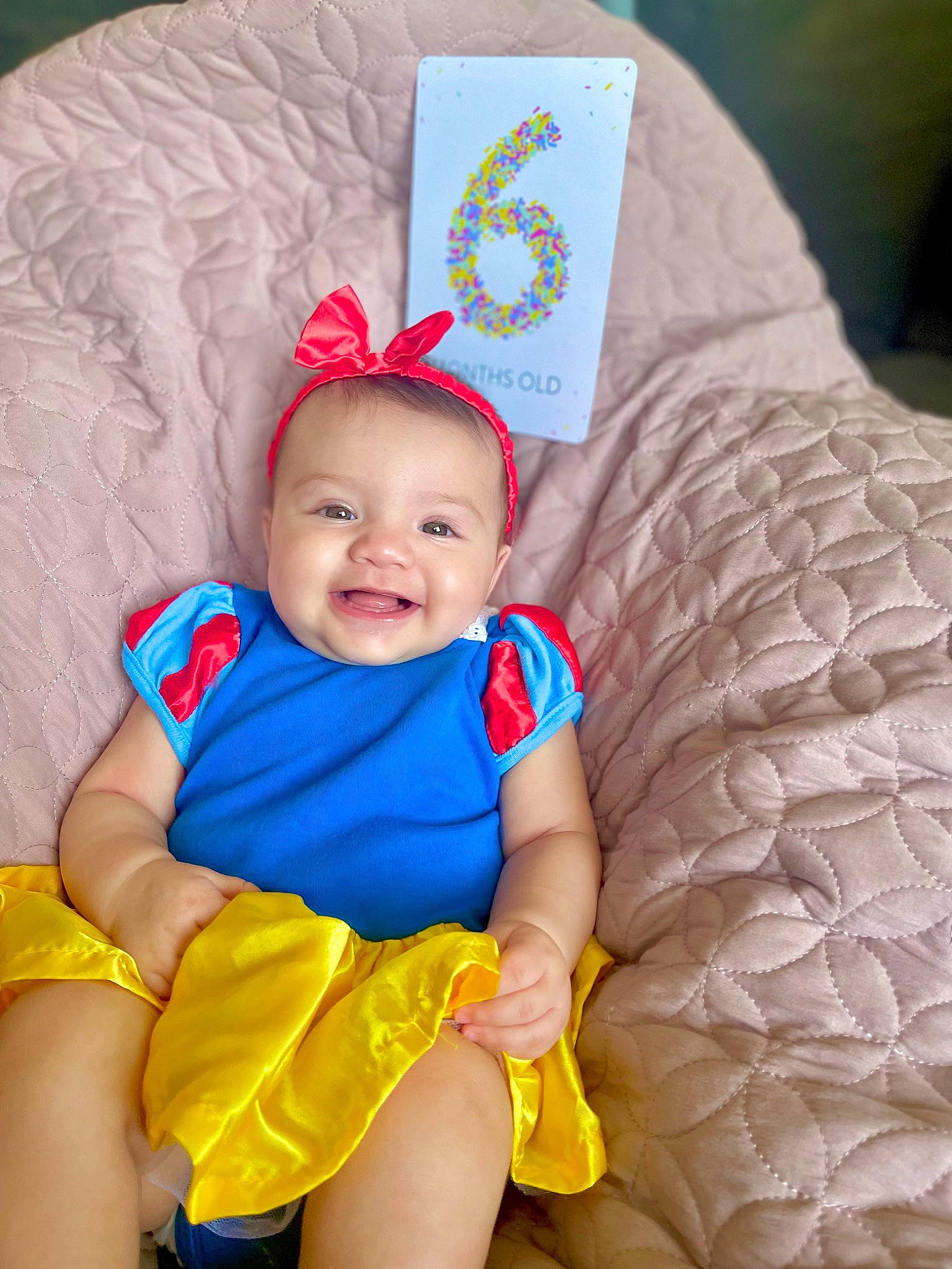 Celeste is registered to the contest to win money with this photo: baby, baby_products, baby_toddler_clothing, child, comfort, costume_hat, couch, electric_blue, event, facial_expression, fashion_accessory, fun, happy, headgear, joy, linens, pattern, person, skin, smile