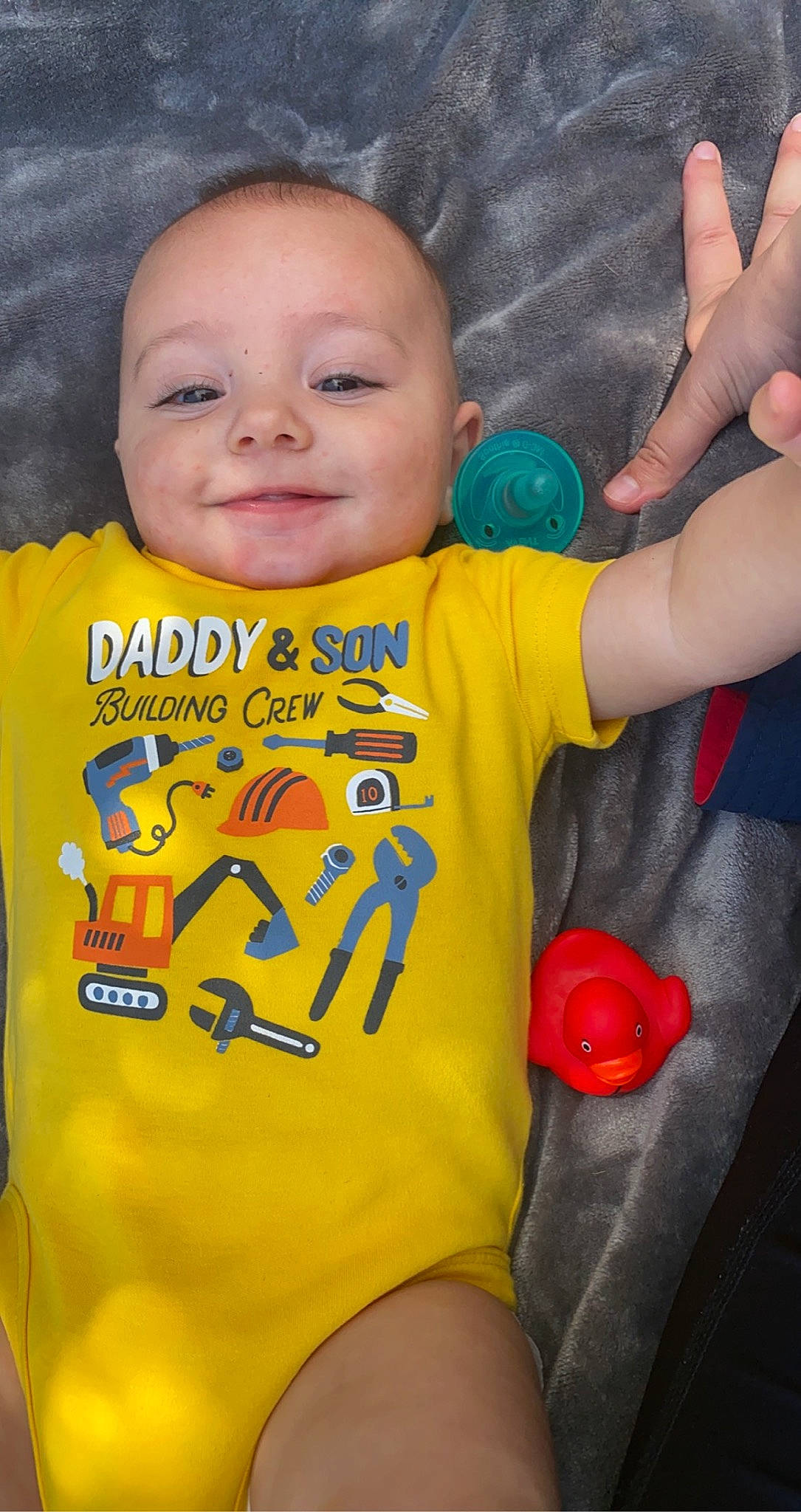 Makai is registered to the contest to win money with this photo: baby, baby_toddler_clothing, cheek, eye, gesture, happy, head, human_body, joy, mouth, neck, nose, orange, organ, person, product, skin, sleeve, smile, t_shirt