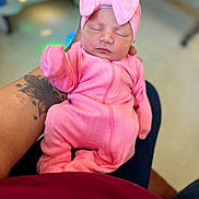 Amoura joined the competition — help win amazing prizes! baby, newborn, infant, pink_clothing, headband, bow, tattoo, arm, sleeping, person, human, indoors, blurred_background, soft_lighting, cozy, cute, cute_baby, child, closeup, portrait