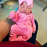 baby, newborn, infant, pink_clothing, headband, bow, tattoo, arm, sleeping, person, human, indoors, blurred_background, soft_lighting, cozy, cute, cute_baby, child, closeup, portrait