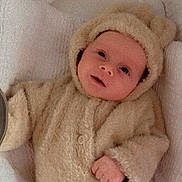 Kéanu joined the competition — help win amazing prizes! baby, infant, child, cozy, soft, blanket, cute, warm_clothing, hood, ears, portrait, lying_down, indoors, fuzzy, buttoned_jacket, newborn, face, hands, sleeping_area, comfort