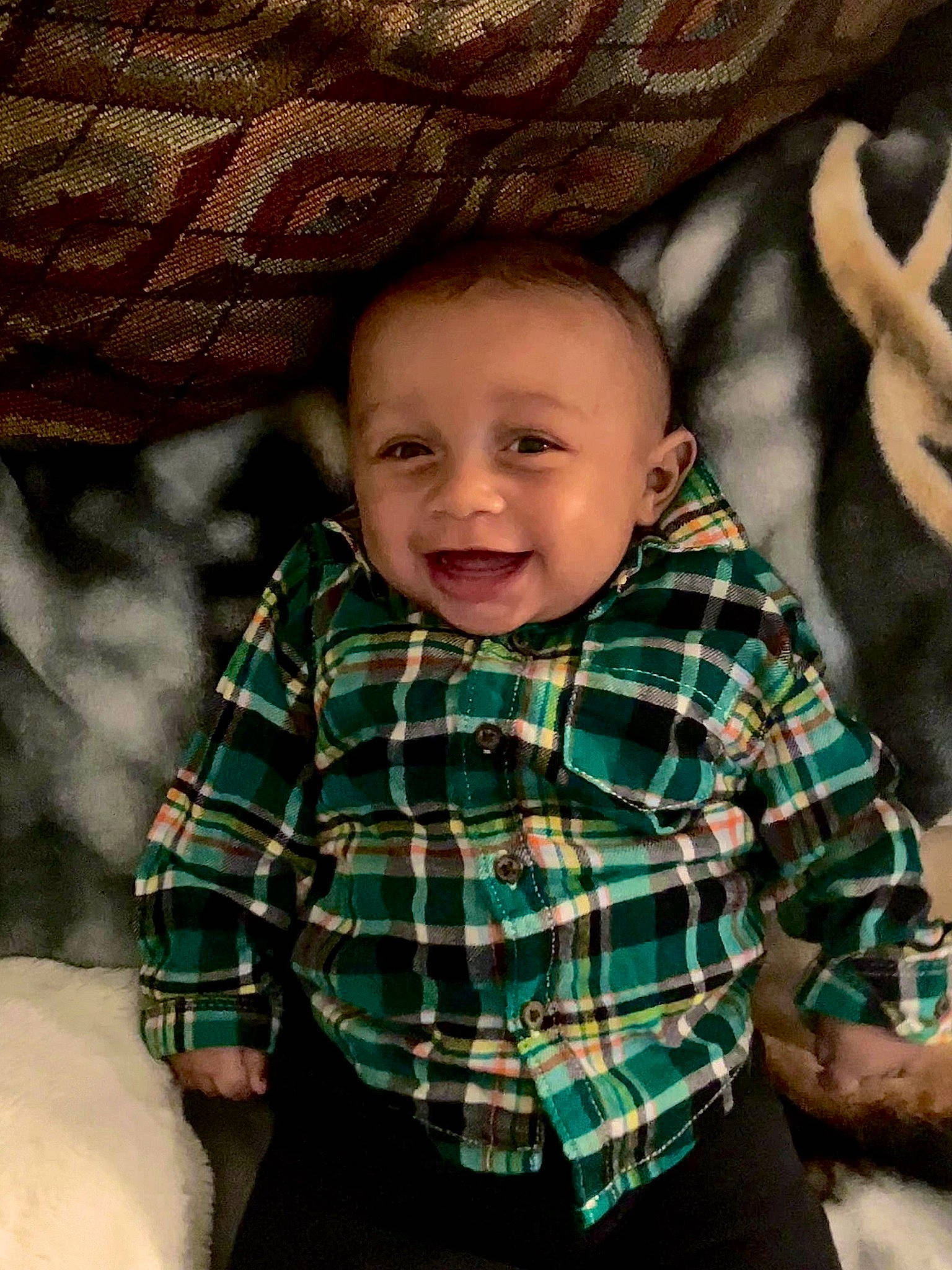Joziah joined the competition — help win amazing prizes! baby, cheek, chin, comfort, finger, fun, gesture, happy, head, human_body, joy, linens, mouth, nose, person, plaid, skin, sleeve, smile, tartan