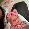 Kennedi is registered to the contest to win money with this photo: baby, child, smiling, pink_bow, headband, pink_outfit, hearts, blanket, couch, indoor, person, face, happy, cozy, portrait, infant, cute, resting, clothing, warm