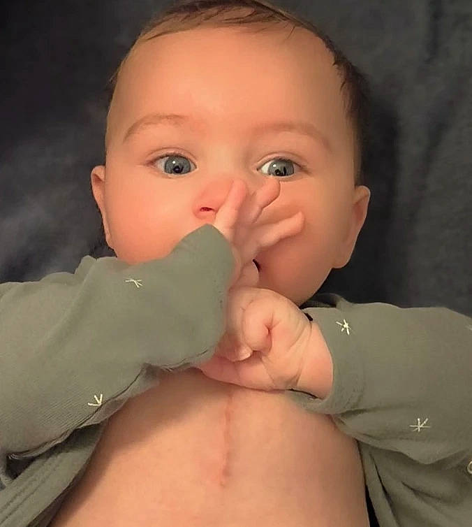 Tylio participe au concours pour gagner de l'argent avec cette photo : arm, baby, baby_toddler_clothing, cheek, chest, ear, eyebrow, eyelash, finger, gesture, hand, happy, human_body, iris, lip, mouth, nose, person, skin, sleeve