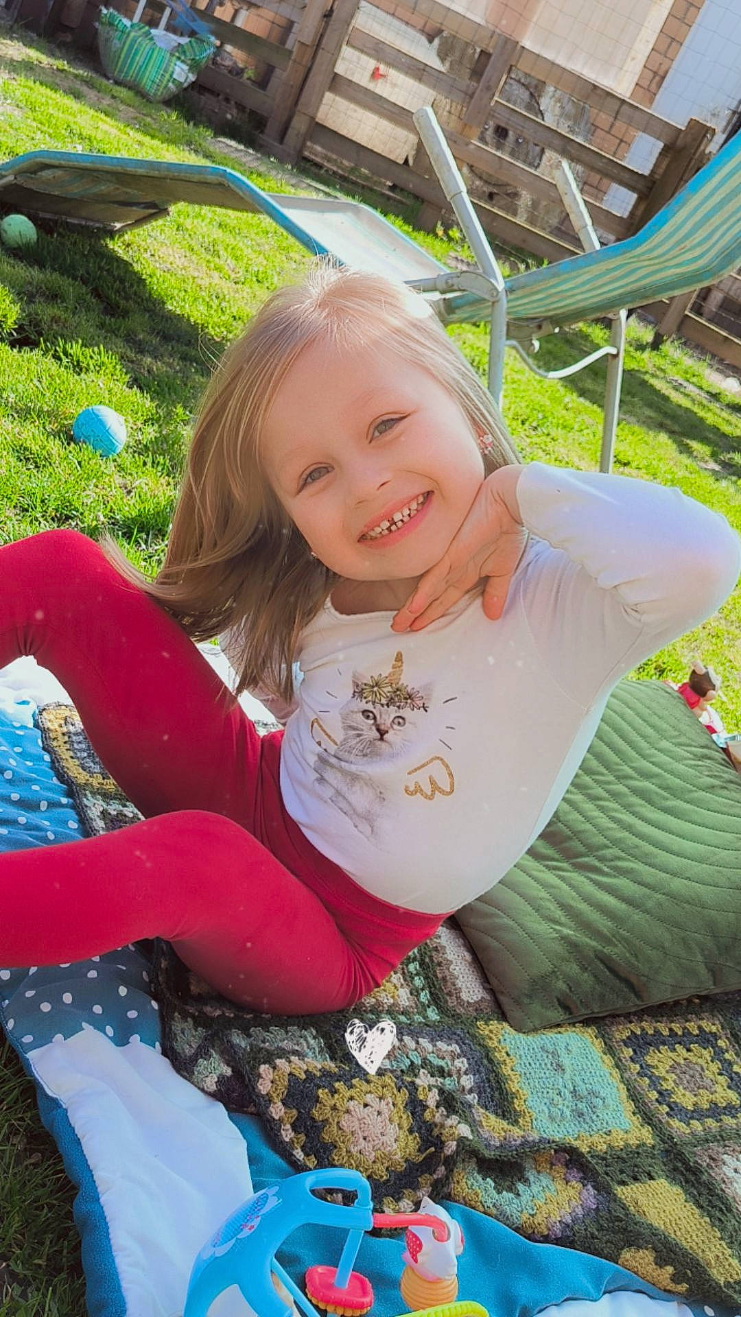 Romane a rejoint le concours — aidez-le/la à gagner de superbes lots ! child, city, facial_expression, fun, grass, hair, happy, joy, leisure, magenta, outdoor_play_equipment, people_in_nature, person, pink, plant, play, playground, recreation, sitting, smile