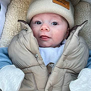 Sonny joined the competition — help win amazing prizes! baby, infant, puffer_jacket, knit_hat, beige, blue_sleeves, mittens, soft_texture, blanket, cozy, cute, face, portrait, child, warm_clothing, closeup, expression, outdoor_gear, newborn, winter_wear