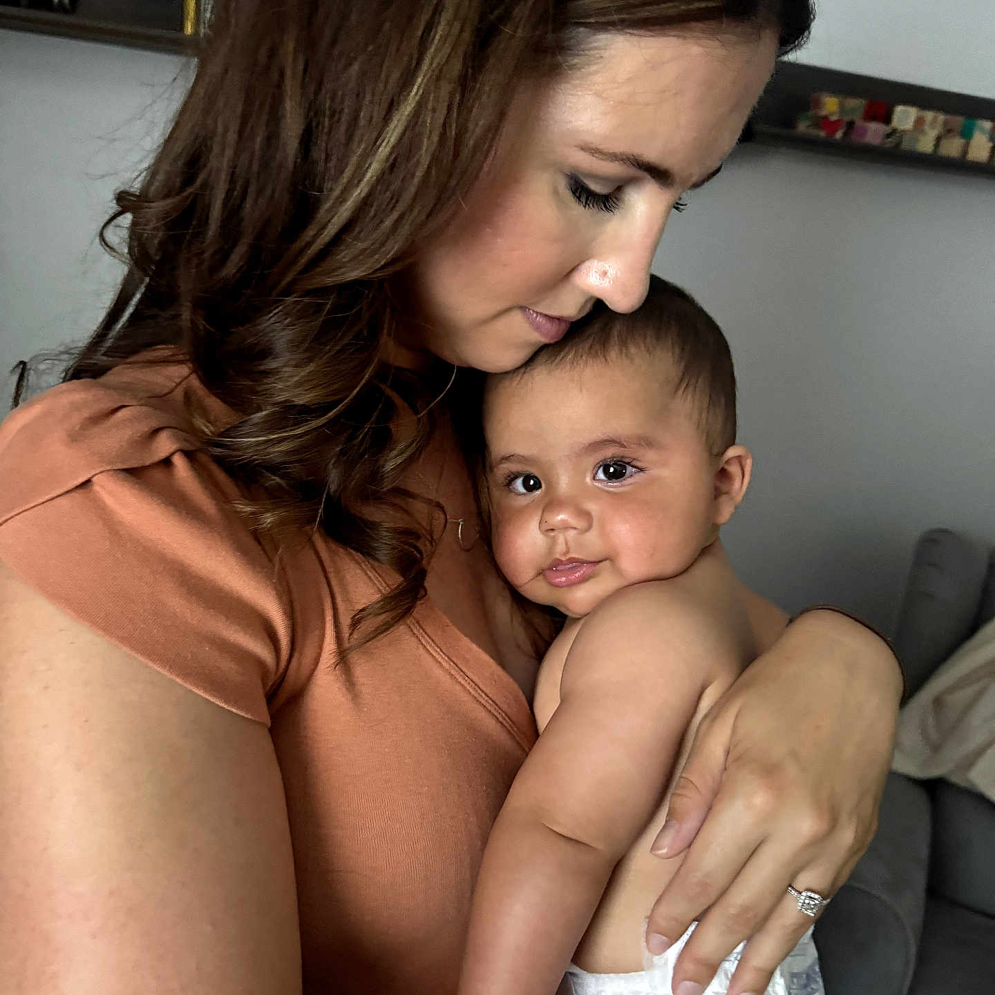 Elijah is registered to the contest to win money with this photo: baby, woman, child, diaper, holding, cuddle, indoor, love, affection, skin, face, person, family, parent, arm, hair, furniture, shelf, home, casual_clothing
