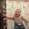 baby, crib, bedding, animal_print, smiling, happy, infant, child, cute, playful, giraffe, elephant, lion, rainbow, stars, clouds, pajamas, blue_pants, beige_shirt, indoor