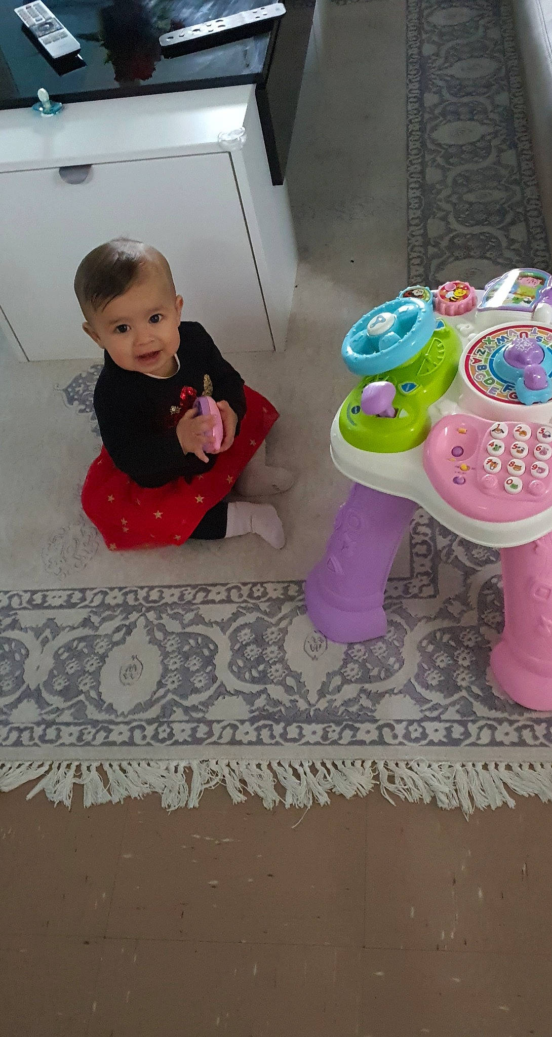 Shahinez a rejoint le concours — aidez-le/la à gagner de superbes lots ! baby, baby_toddler_clothing, baby_toys, carpet, cheek, child, comfort, crawling, floor, flooring, fun, magenta, pattern, person, pink, play, room, sitting, smile, toddler