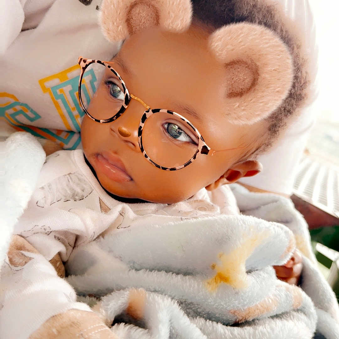 Asher is registered to the contest to win money with this photo: accessories, architecture, baby, blanket, bodypart, building, face, finger, glasses, hand, happy, head, hospital, newborn, person, photography, portrait, smile, spa, toy