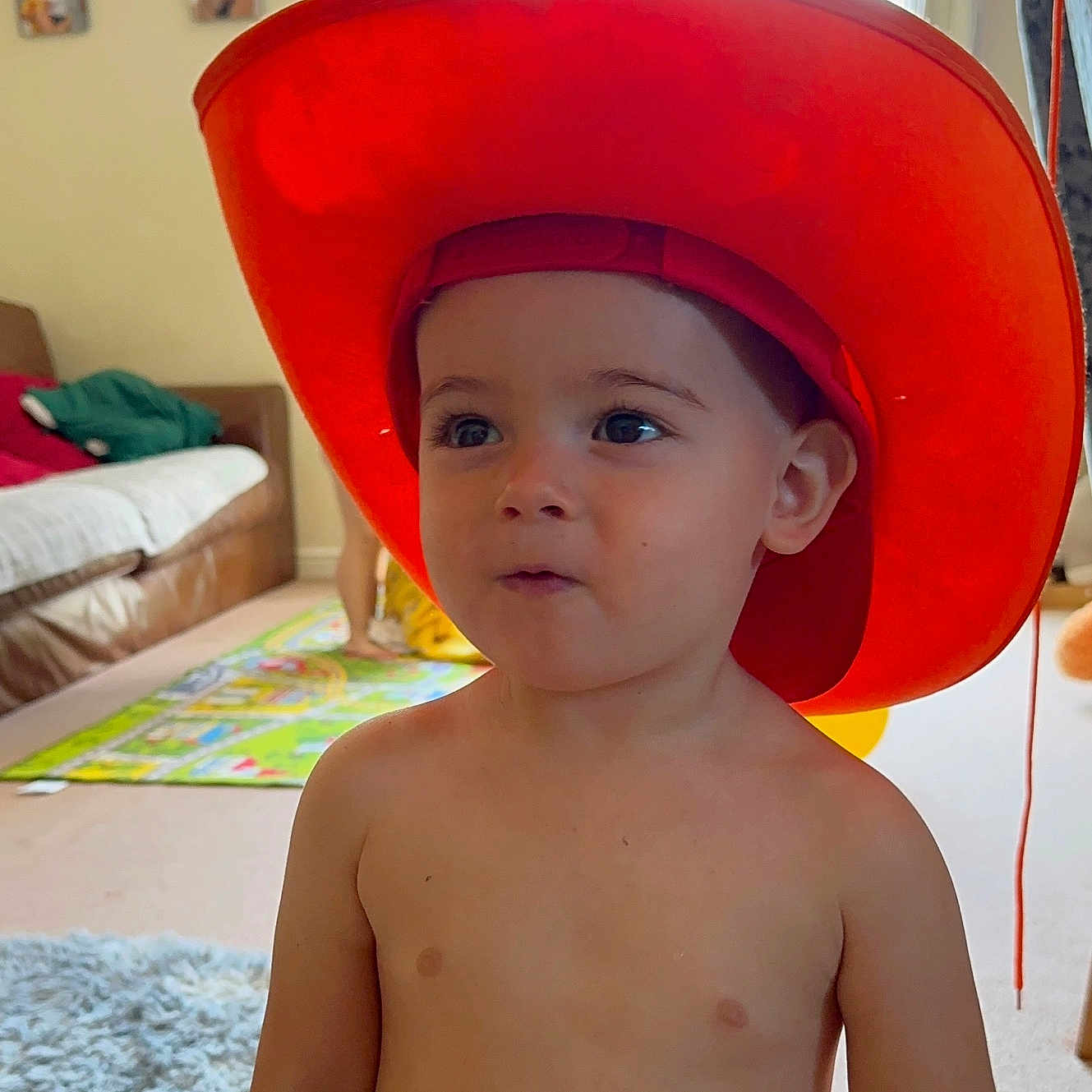 Tudor joined the competition — help win amazing prizes! bright, carpet, child, couch, curious, expression, family_photos, furniture, hat, home, indoor, living_room, orange, person, portrait, rug, shirtless, toddler, window, young_child