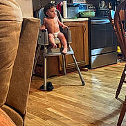 Porter joined the competition — help win amazing prizes! toddler, child, high_chair, diaper, kitchen, wooden_cabinets, stainless_steel_appliance, floor, tattoo, arm, chair, paper_towel, pot, pan, countertop, table, wooden_floor, person, indoor, home