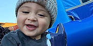 Ezekiel is registered to the contest to win money with this photo: toddler, child, beanie, hat, smile, toy, inflatable, bounce_house, outdoor, grass, sky, portrait, happy, face, hand, long_sleeve, clothing, playful, weekend, photography