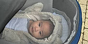 Andres is registered to the contest to win money with this photo: baby, stroller, hoodie, mesh_screen, outdoor, child, face, wheel, pavement, clothing, blanket, cute, infant, person, transport, warm, walking, footpath, casual, small