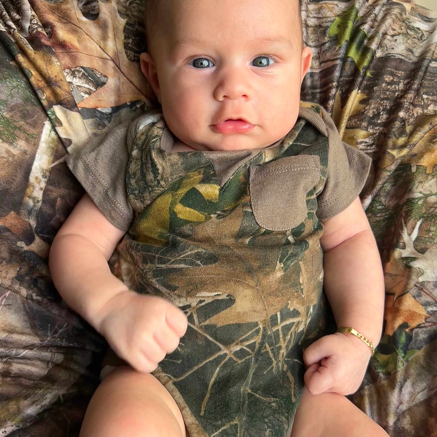 Liam is registered to the contest to win money with this photo: accessories, arm, army, art, baby, bed, blanket, blazer, blonde, bodypart, bracelet, camouflage, chair, clothing, coat, costume, couch, crawling, cushion, diaper